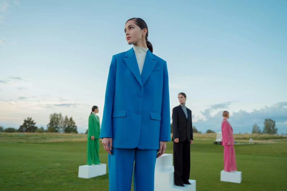 women standing in colored outfits
